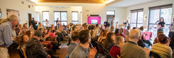 seated crowd seen from the side while watching a presentation