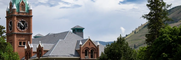 Main Hall beneath a blue sky at the University of Montana campus.