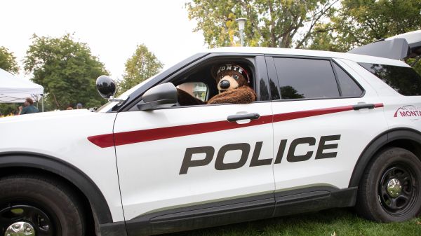 Monte the UM mascot sitting in a UM police car