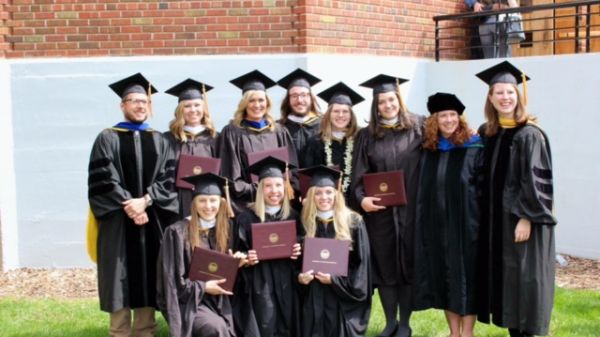 A group of graduate students and faculty wearing graduation regalia