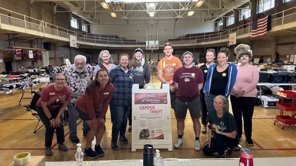 a group of volunteers poses in schrieber gym right before campus thrift sale