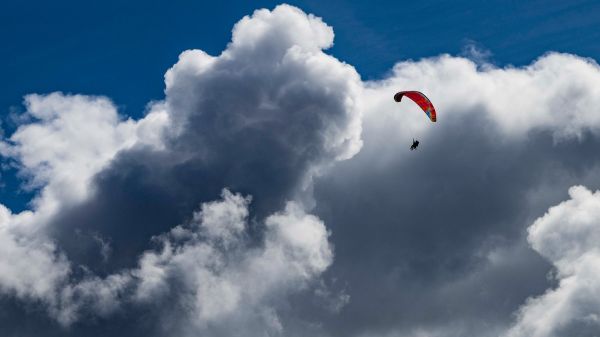 image of a single paraglider floating through a big white cloud