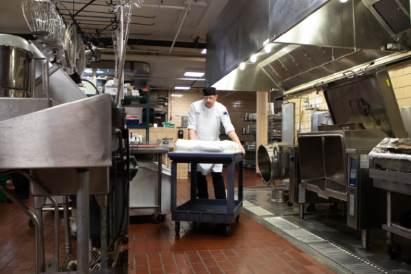 chef pushing cart in kitchen