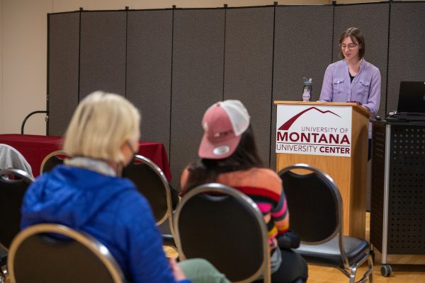A speaker presenting to audience at a campus event. 