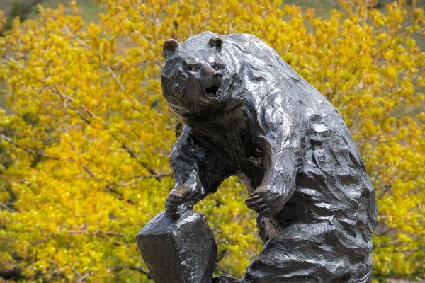 Griz statue with trees and flowers