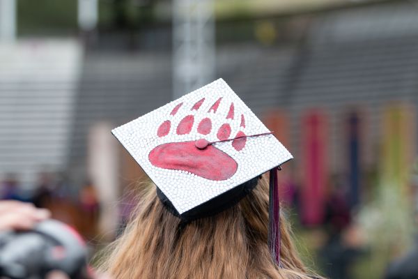 Graduation cap on graduating student with griz paw on top