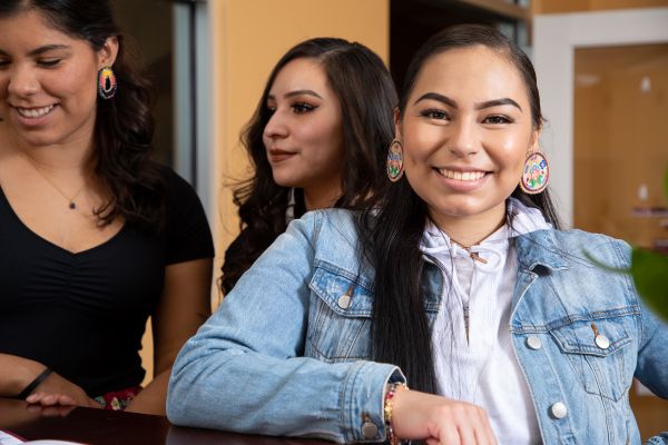 Three native students standing at a counter