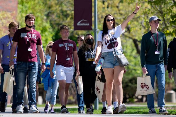 A campus tour guide leads visitors on a tour