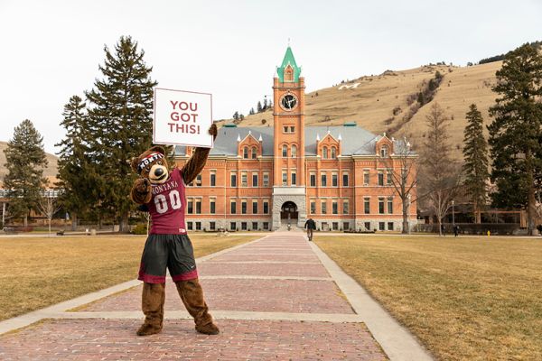 Monte the mascot holding a sign in front of Main Hall that reads: "YOU GOT THIS."
