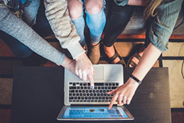 3 students working together on a laptop