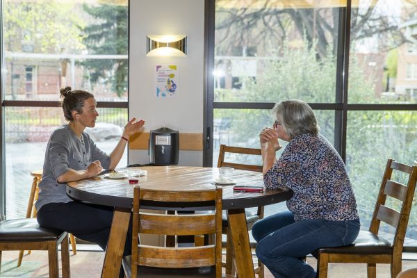 Two women in practicum, talking at a table