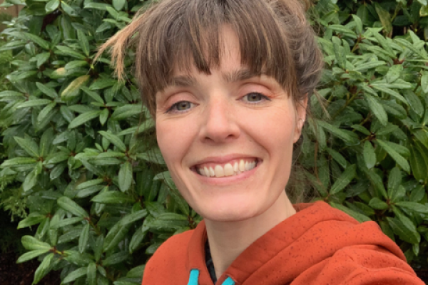 headshot of Dr. Hannah Sipe with a green bushy plant in the background