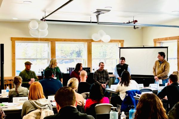 group of individuals receiving a training in an in-person setting with a whiteboard in the front of the class.