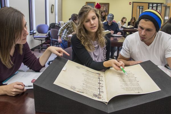 students looking at a medieval manuscript