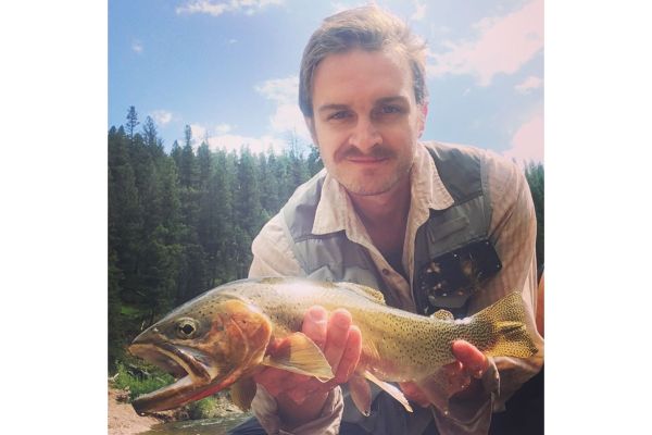 Joseph Denhert posing with small fish