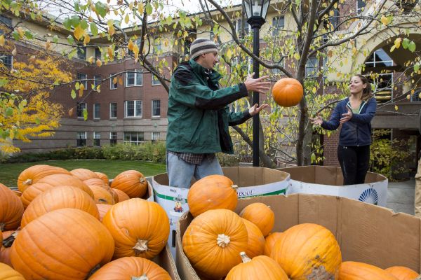 student tossing a pumpkin