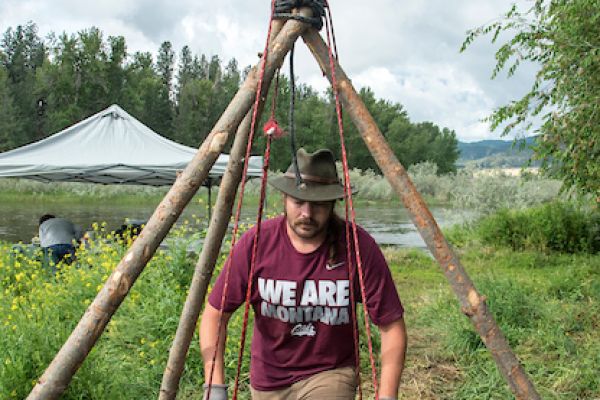 student with wheelbarrow under tripod
