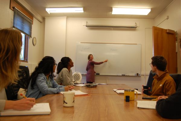 amanda dawsey teaches at white board to students around a table