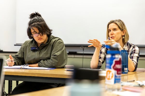 teacher and student sit at table and discuss