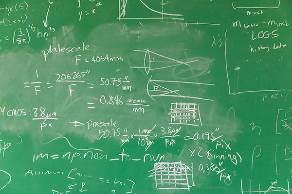 equations in chalk on a green board