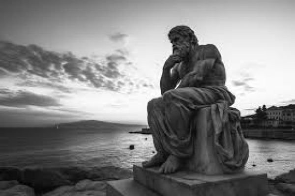 statue of rodin thinking on a beach in black and white