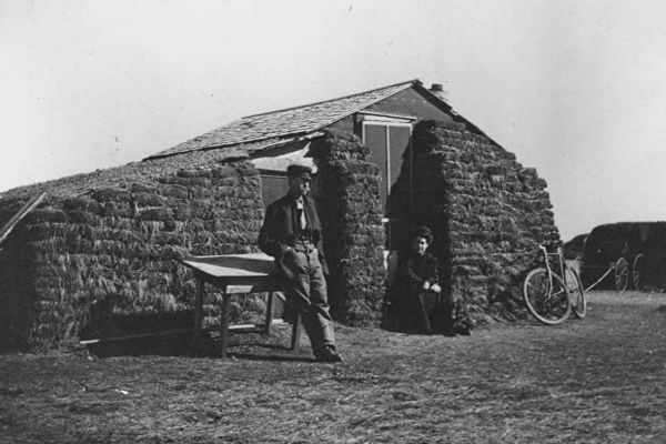 Homesteading couple outside a dwelling near Judith Gap, Montana
