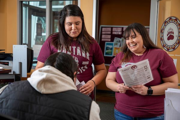 two native students ask a question in american indian services office