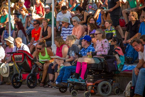 Woman in a wheelchair in crowd of an outdoor concert