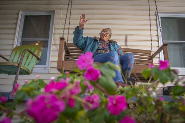 Woman waving on a porch swing