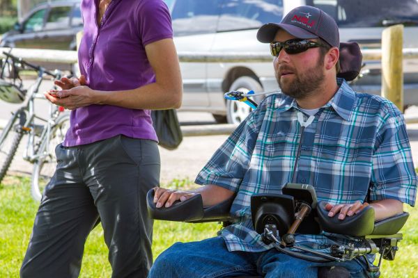 Man who uses a wheelchair having a conversation in a park