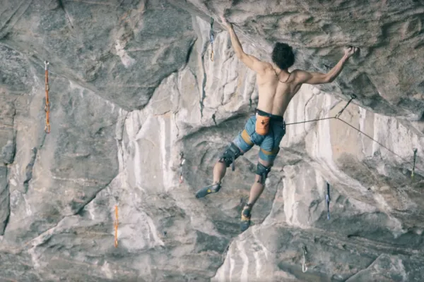 climber hanging underneath a outcropping of rock