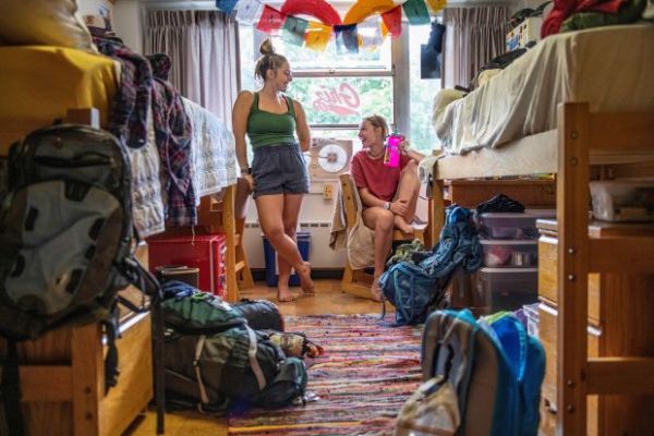 two girls smiling in a dorm
