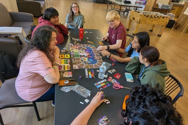 Staff and Students playing a board game that teaches the Blackfeet language