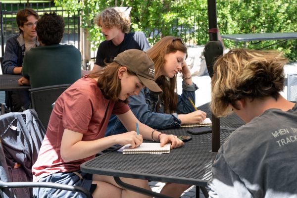 student taking notes at the DHC patio