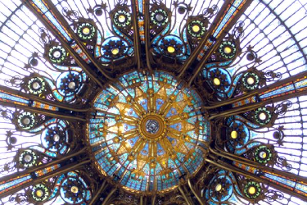 ceiling of a building from below with stained glass and other designs