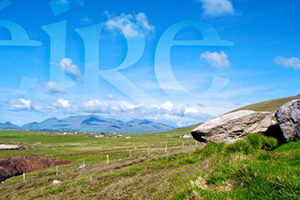girl stands on a rock overlooking green landscape