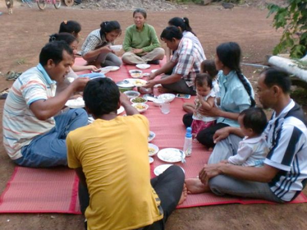 outdoor picnic with 10 people sitting in a circle on a blanket