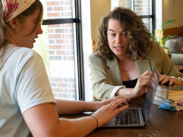 student receiving help while working on her laptop