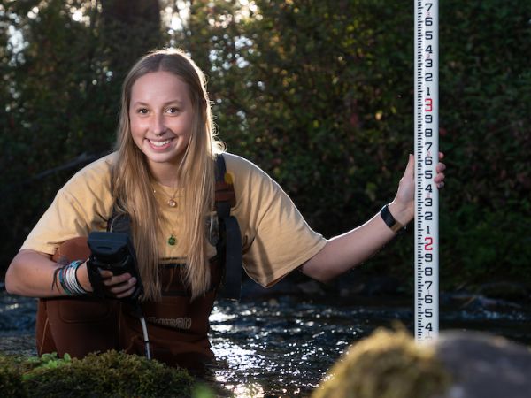 A geoscience student surveys Rattlesnake Creek