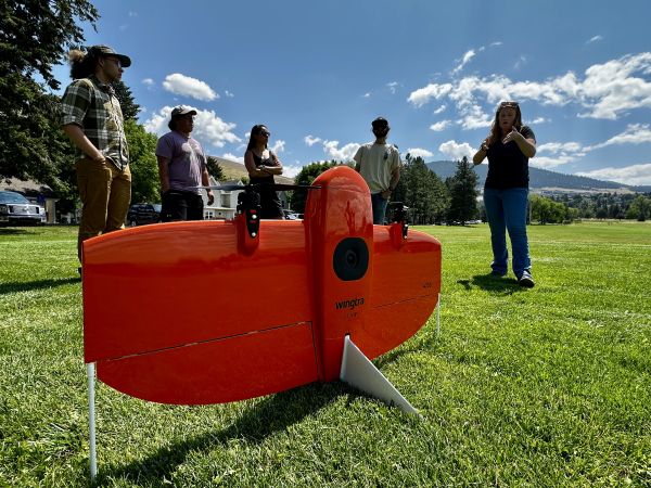 people gathered around a wingtra drone on a field