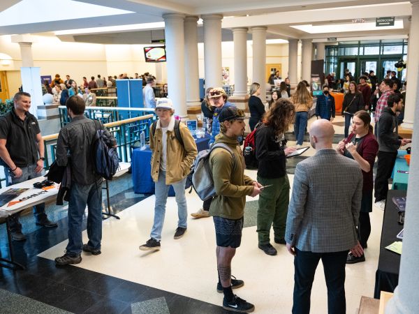 Students mingle inside the Gallagher Business Building during a career day