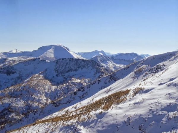 Snow covered mountain tops under a blue sky.