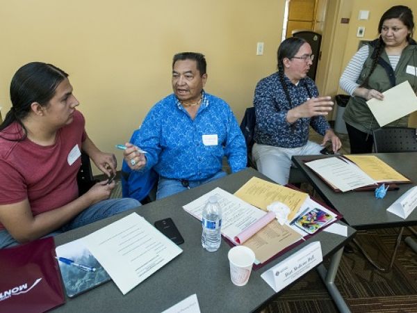 several people sit at a table in discussion