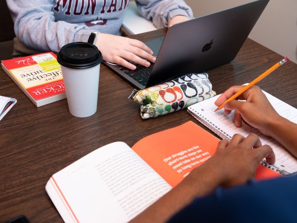 students participating in a study session with books and laptops