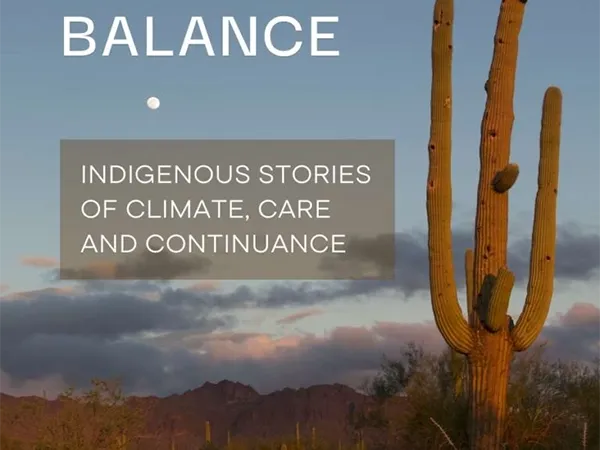 Holding the World in Balance book with photo of a cactus and the moon during dusk