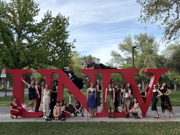 dance team posing on letters 'UNIV'