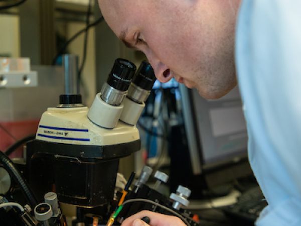Student examining samples under a microscope