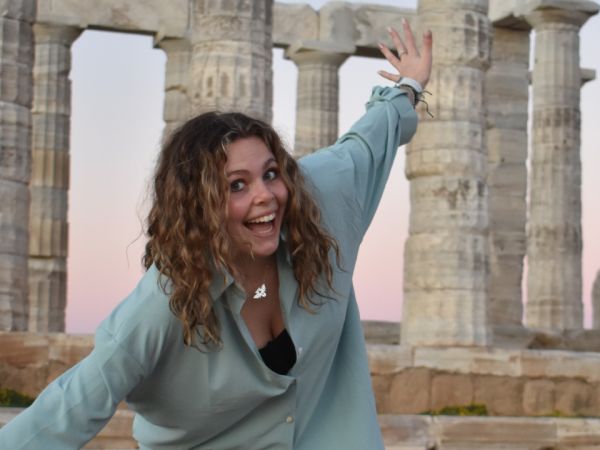 Woman posing in front of Greek monument