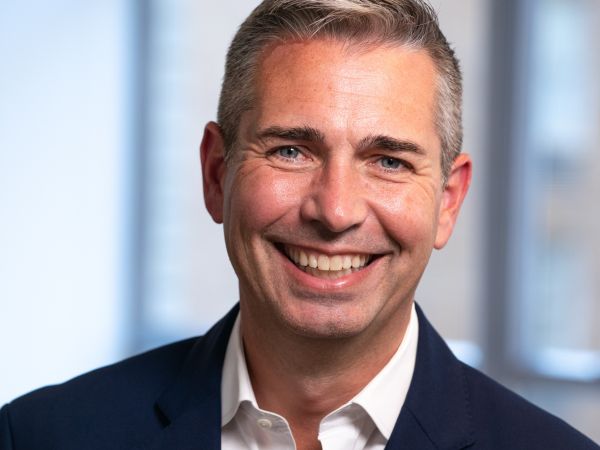Head photo of Tom Lopach in a suit smiling at the camera