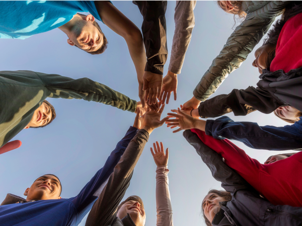 Four abstract persons holding hands in the center